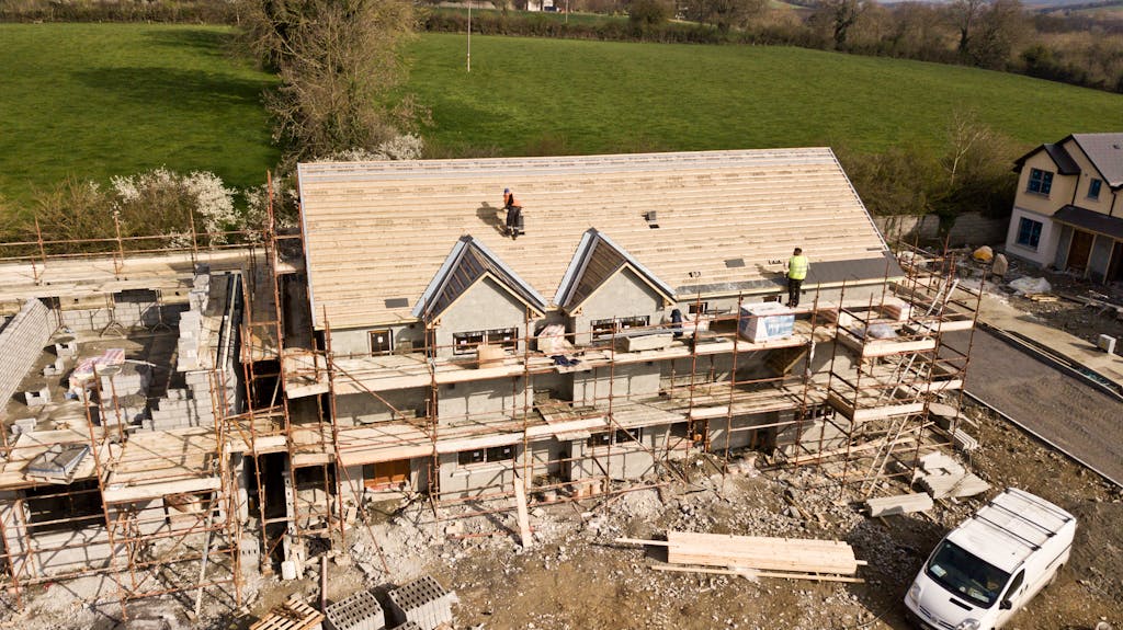 Maison en construction avec échafaudages et ouvriers
